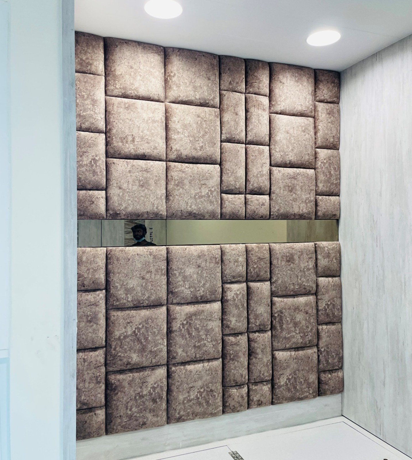 Upholstered cushioned wall panelling behind a bed