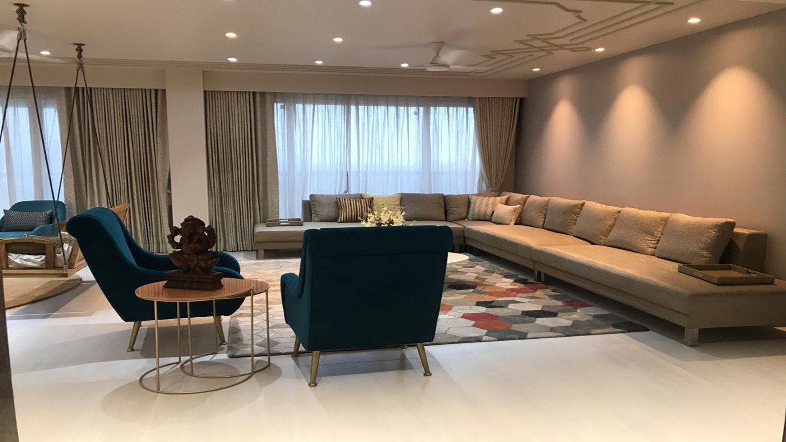 Curved brown sofas under a sculptural ceiling