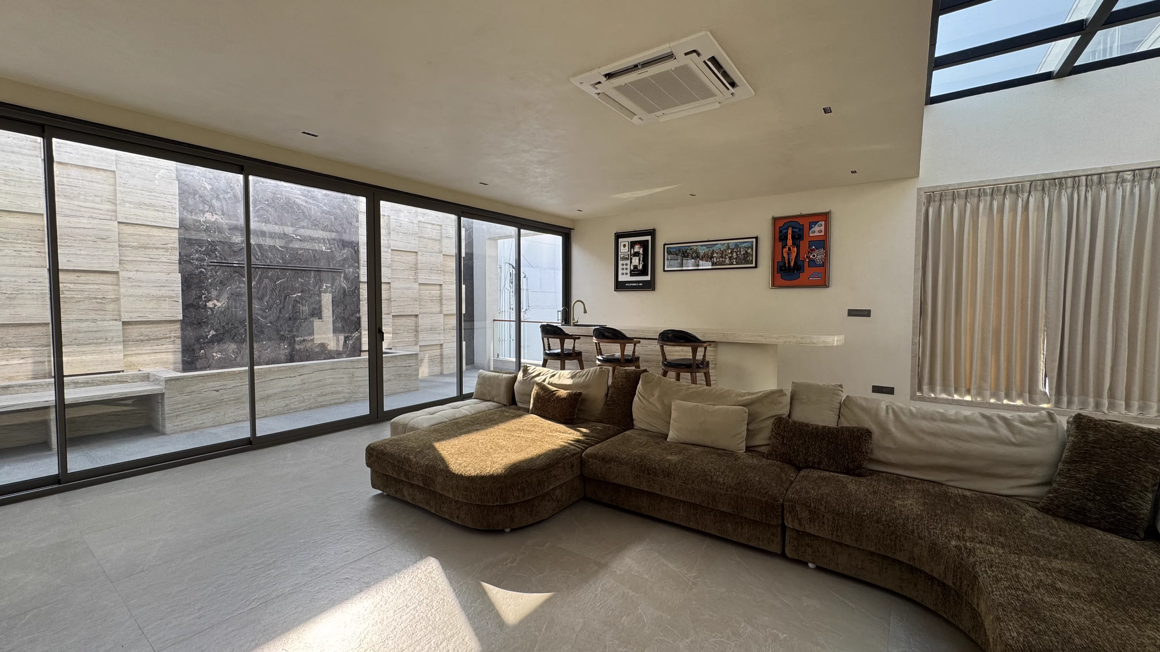 Brown sectional sofa beside floor-to-ceiling windows