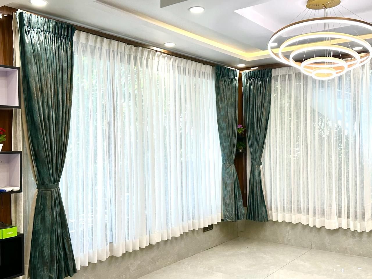 Teal velvet and white sheer curtains in a Chennai living room