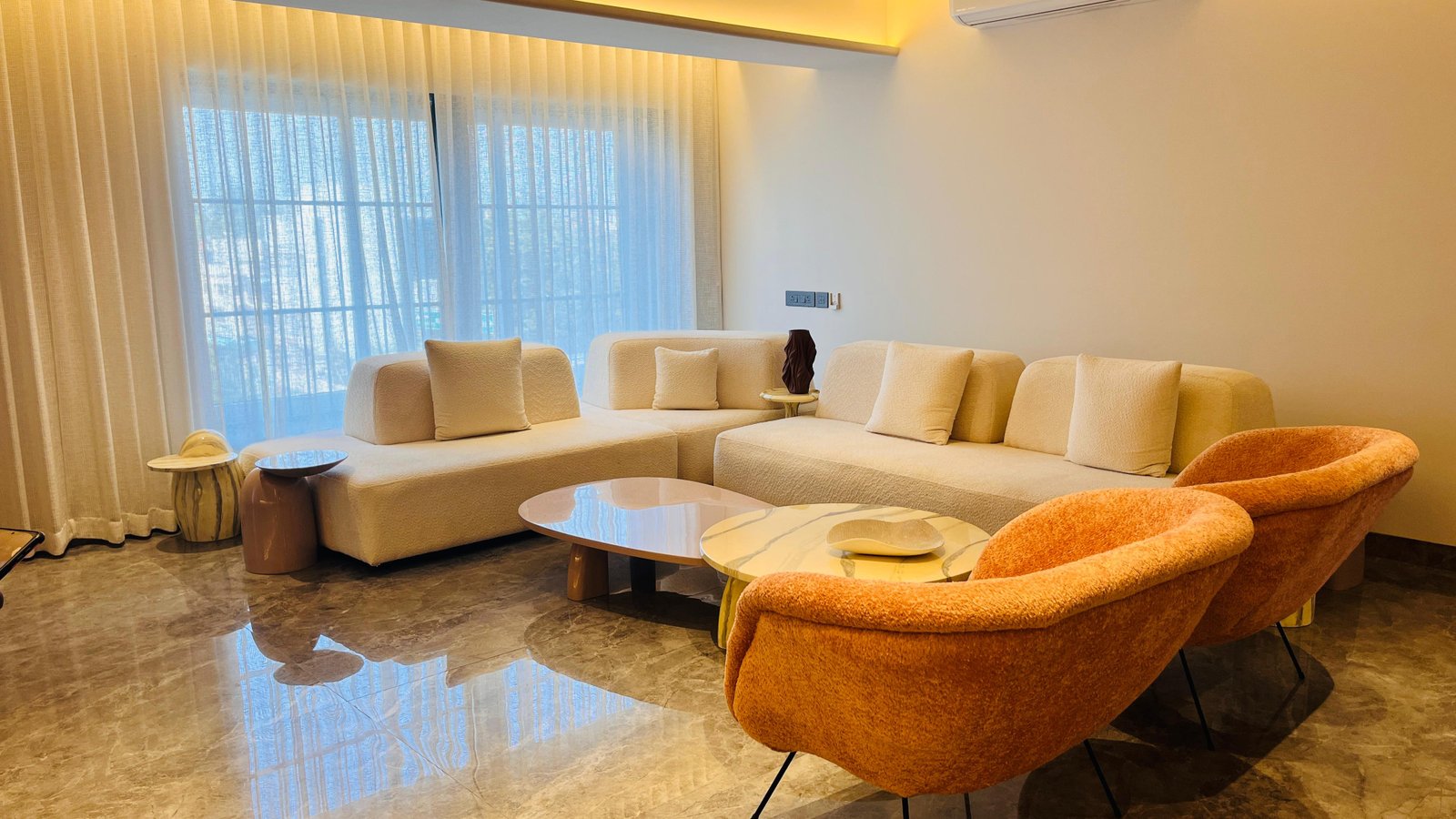 Cream boucle modular sofa with orange accent chairs