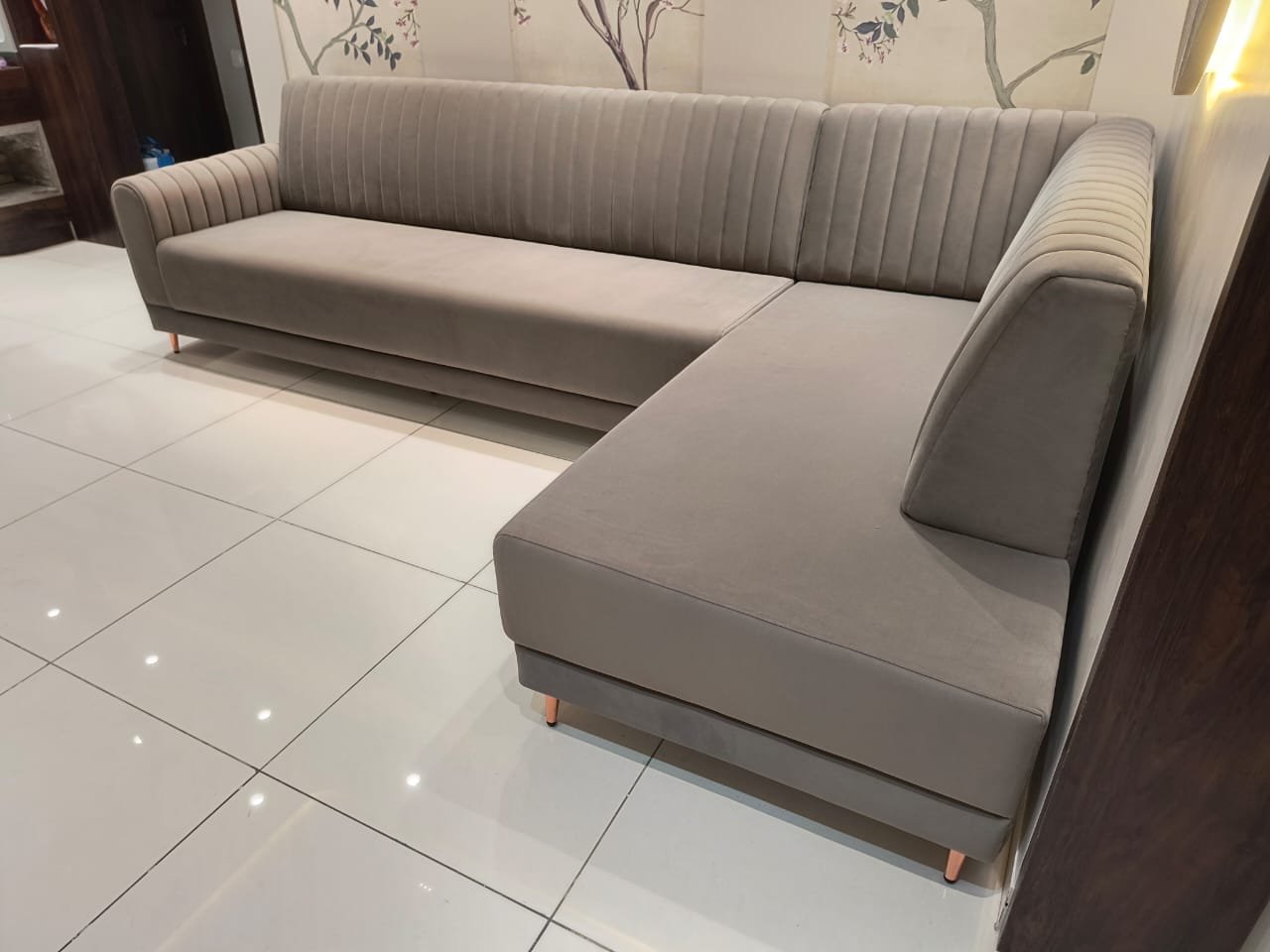 Grey velvet L-shaped sofa with channel stitching